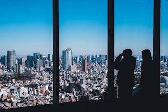 Two entrepreneurs celebrating a successful business milestone with a city skyline in the background.