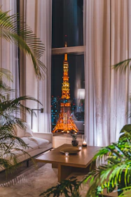 A sleek, modern living room with soft neon lighting and large glass windows overlooking Hyderabad’s skyline.