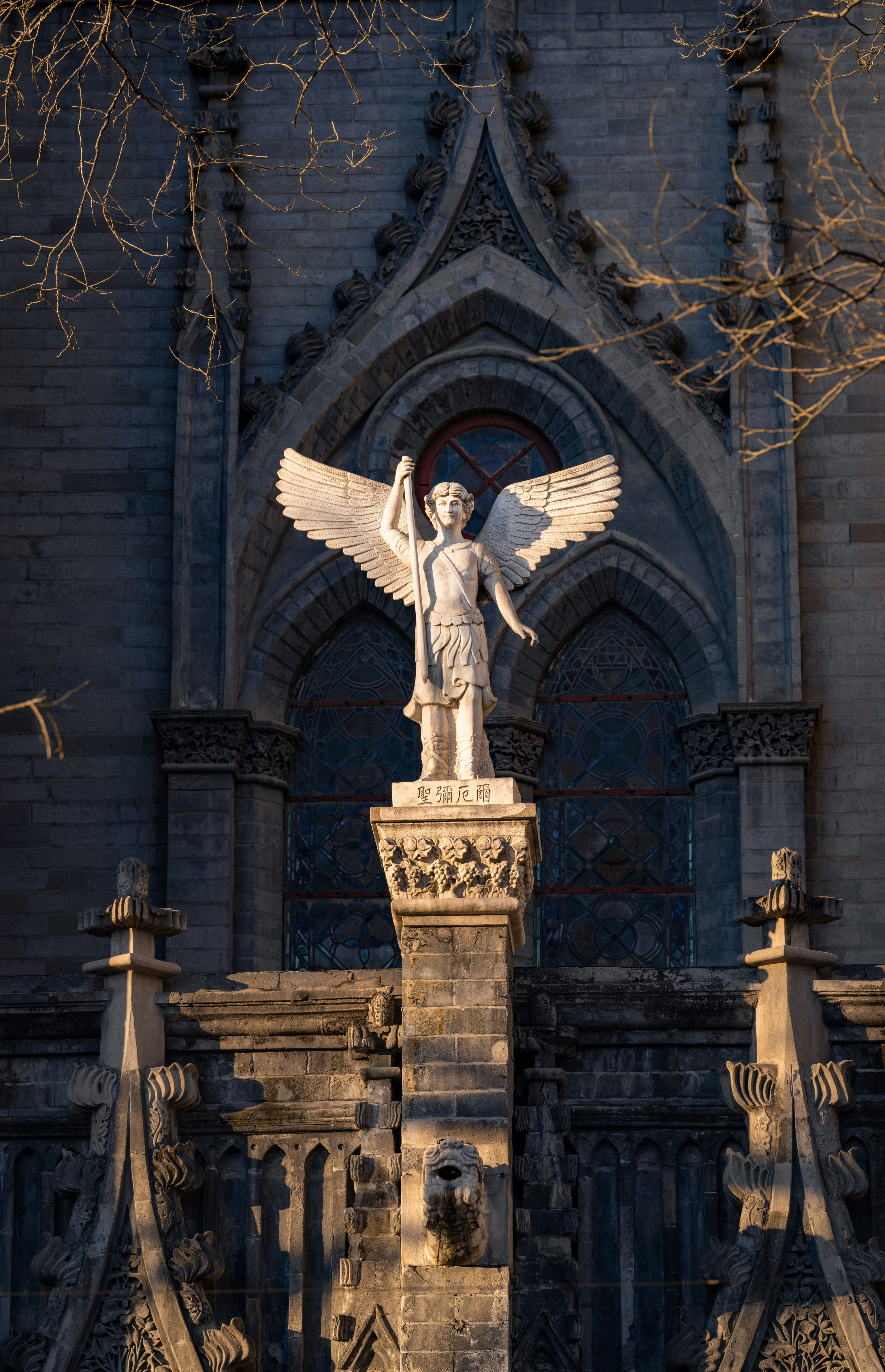 A statue and church facade detail photographed in China.