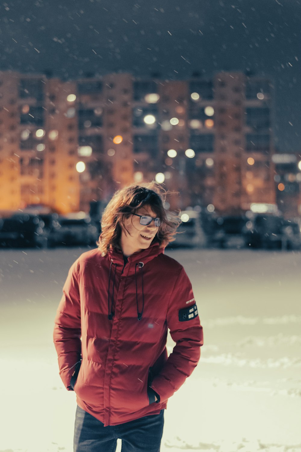 a man in a red jacket standing in the snow