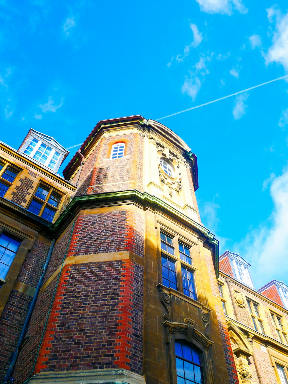 a tall brick building with a clock on it's side