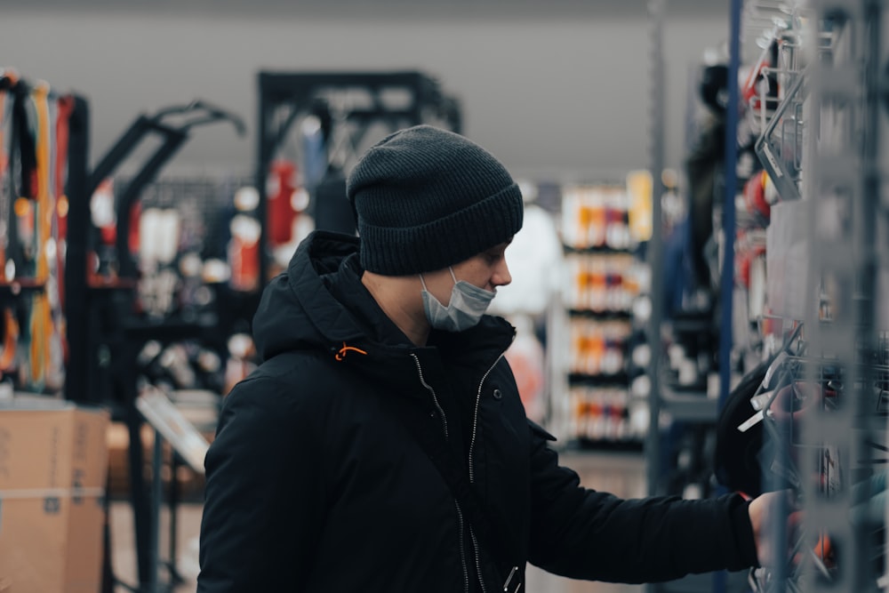 Ein Mann mit Gesichtsmaske und Handschuhen in einem Geschäft