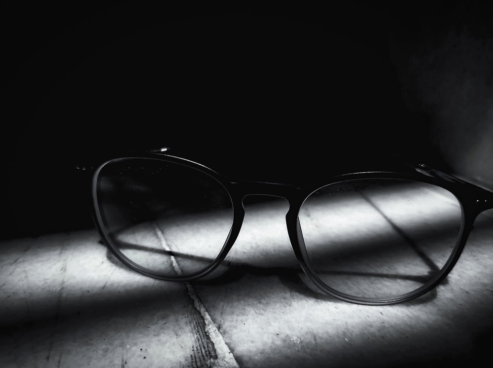 a pair of glasses sitting on top of a wooden table