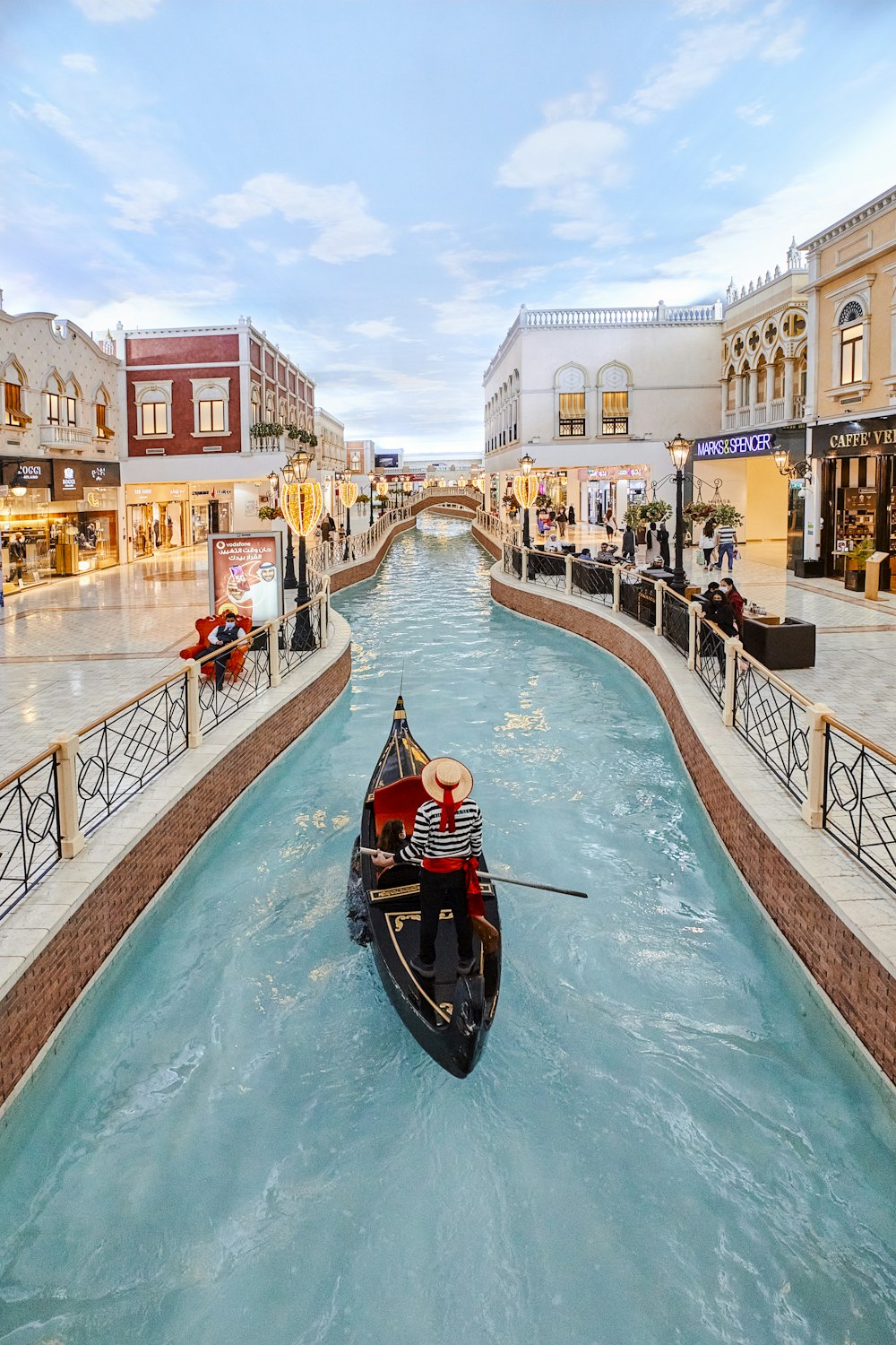 a gondola in the middle of a canal in a shopping district
