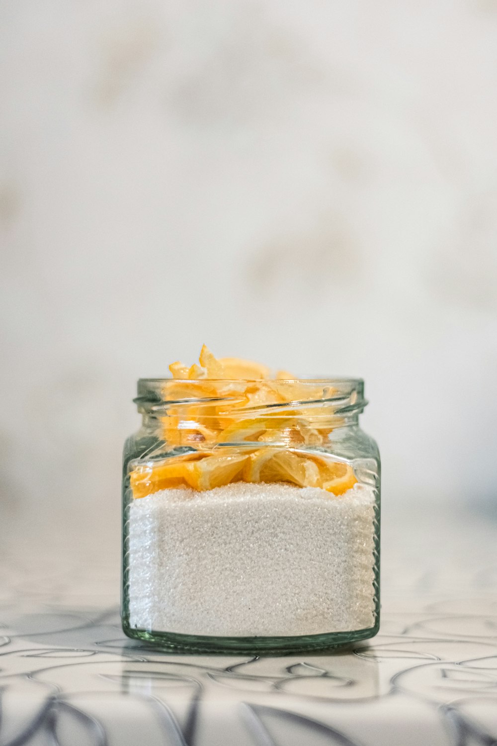 a glass jar filled with sugar and orange peels