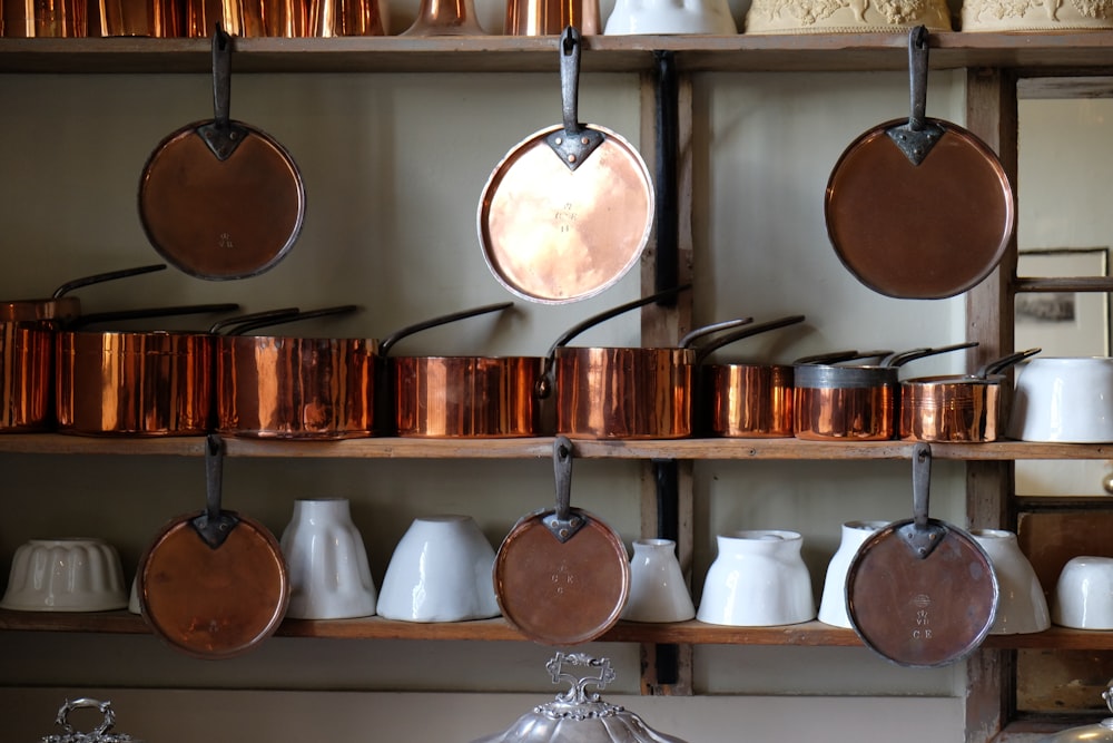 pots and pans are hanging on a shelf