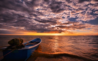 A calm maritime scene with a small boat on deep blue water at sunset, symbolizing trust and professionalism.