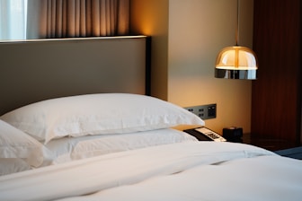 luxury standard hotel level care a bed with white pillows and a phone on it