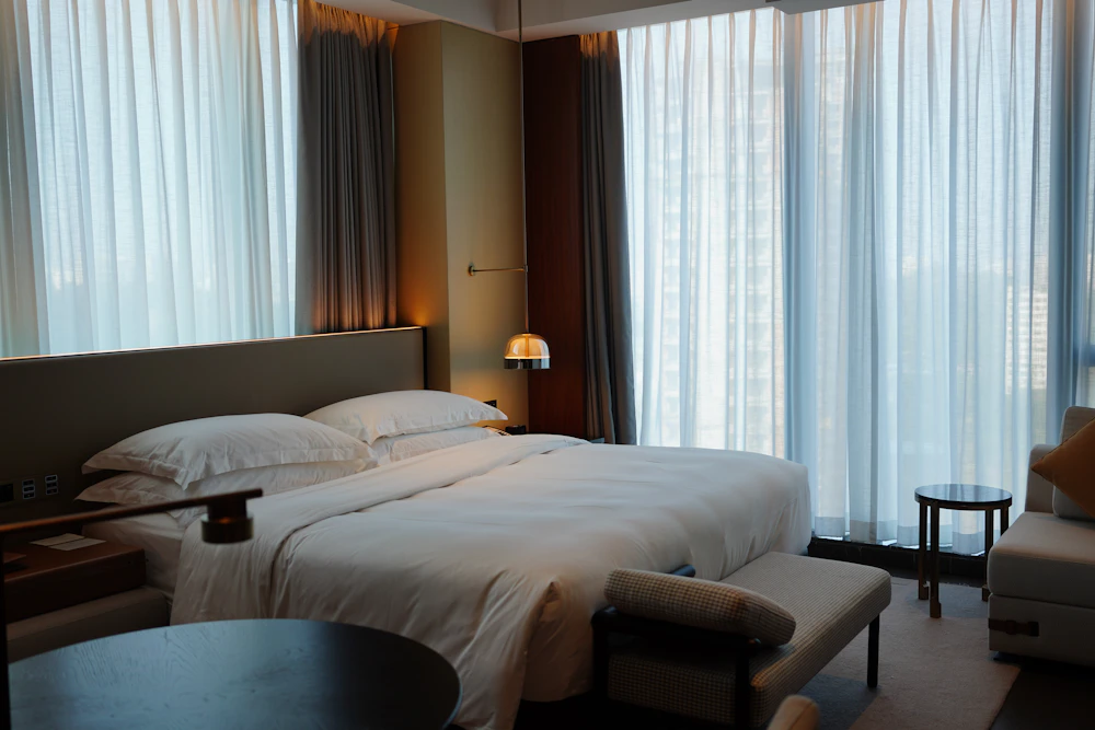 Corner King bed beside a large window