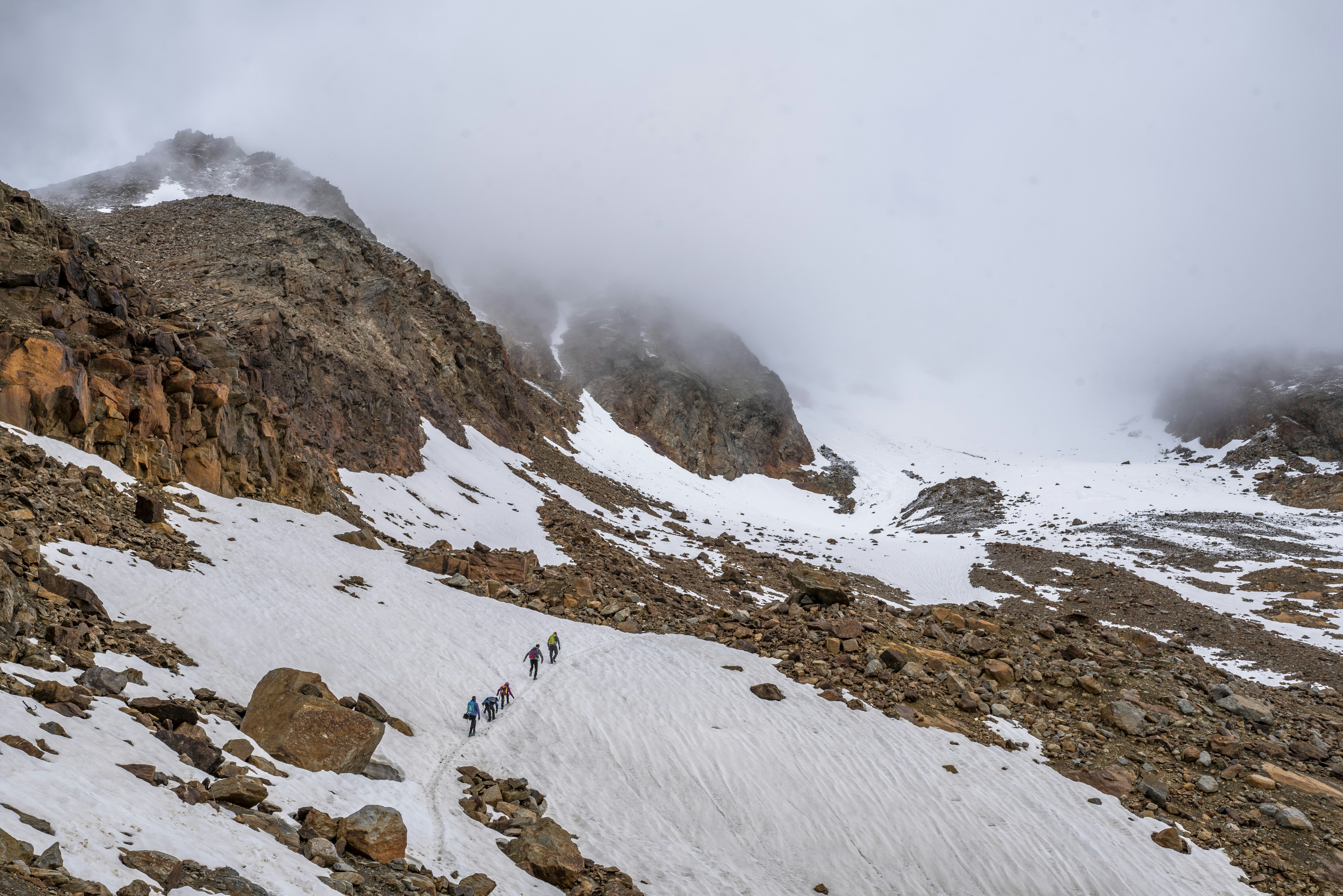 a group of people hiking up a snow covered mountain