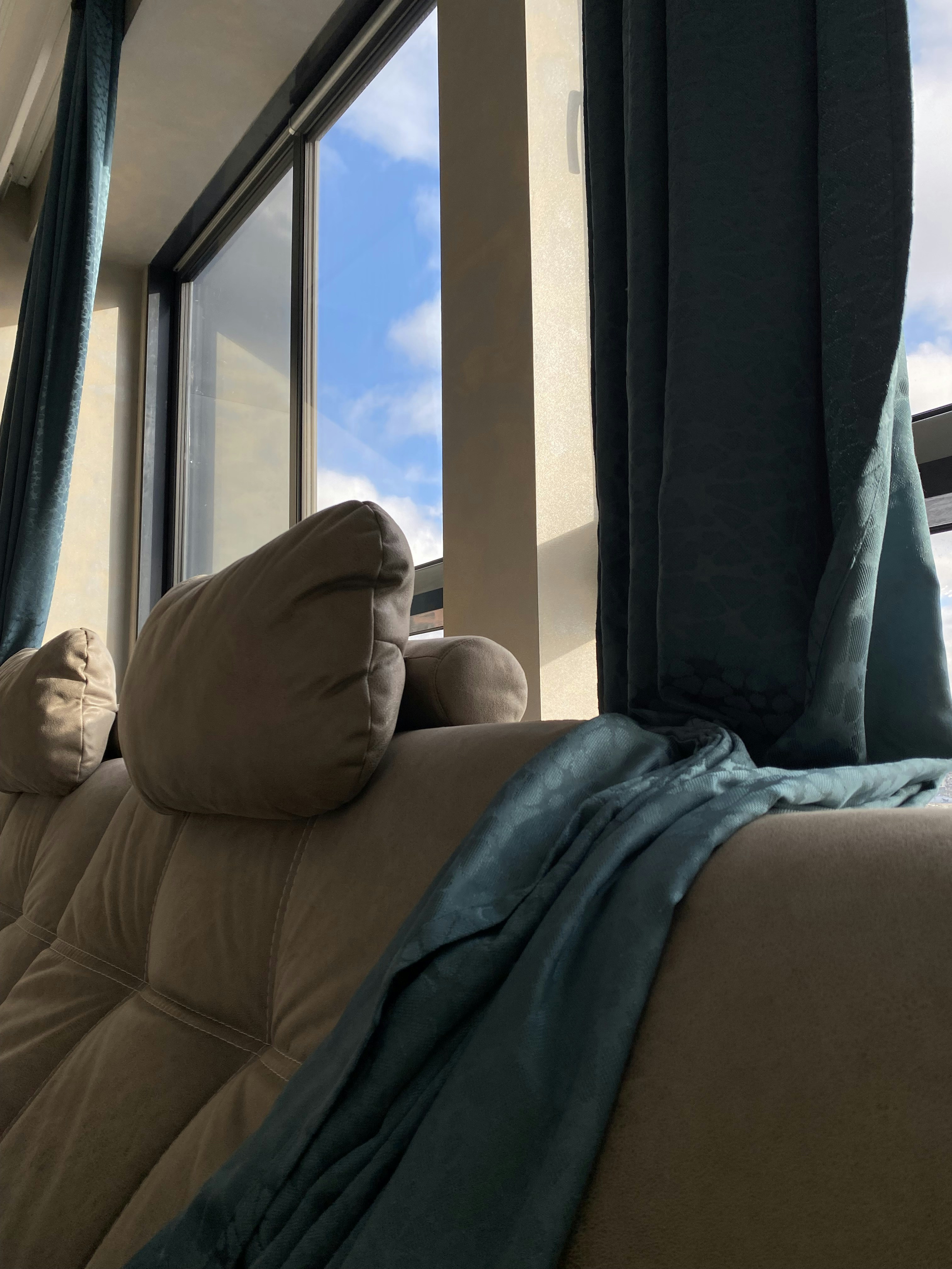 窓の横の毛布が置かれたソファ