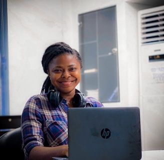 a woman sitting in front of a laptop computer