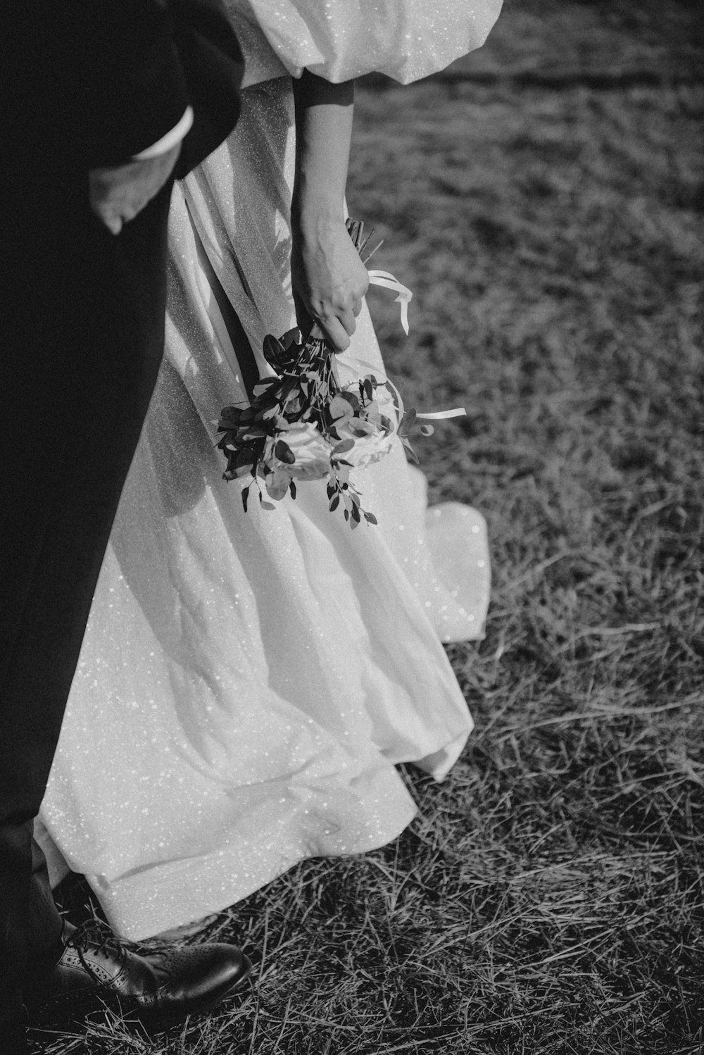 a bride and groom holding hands in a field