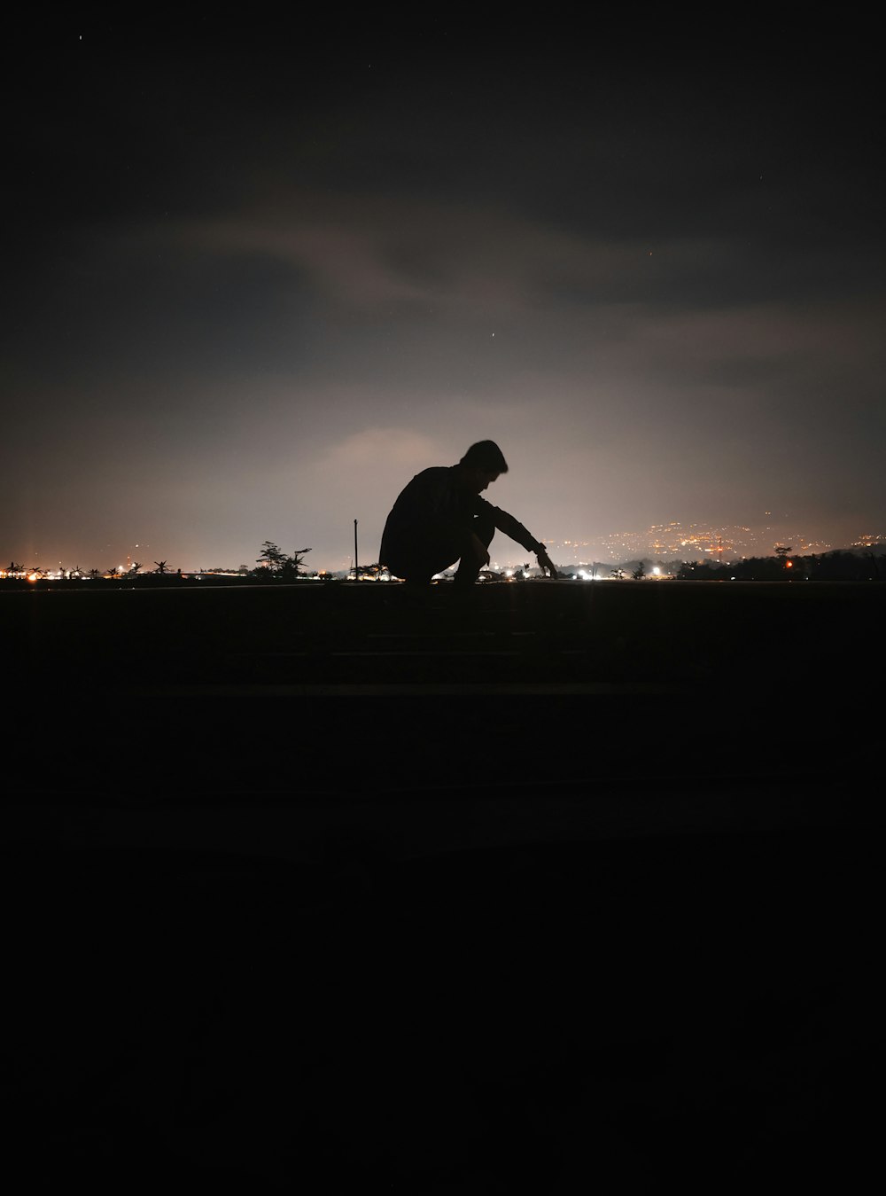 a man sitting on a bench in the dark