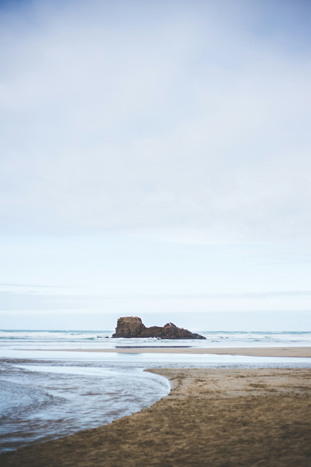 a person walking on a beach with a surfboard