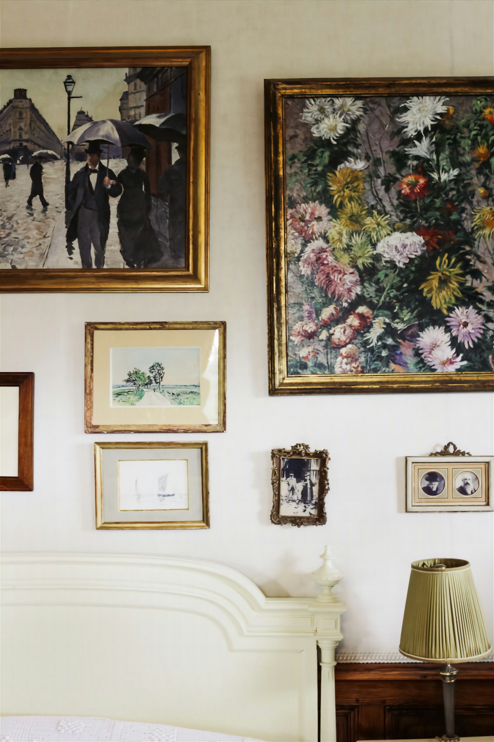 a bedroom with paintings on the wall and pictures on the wall