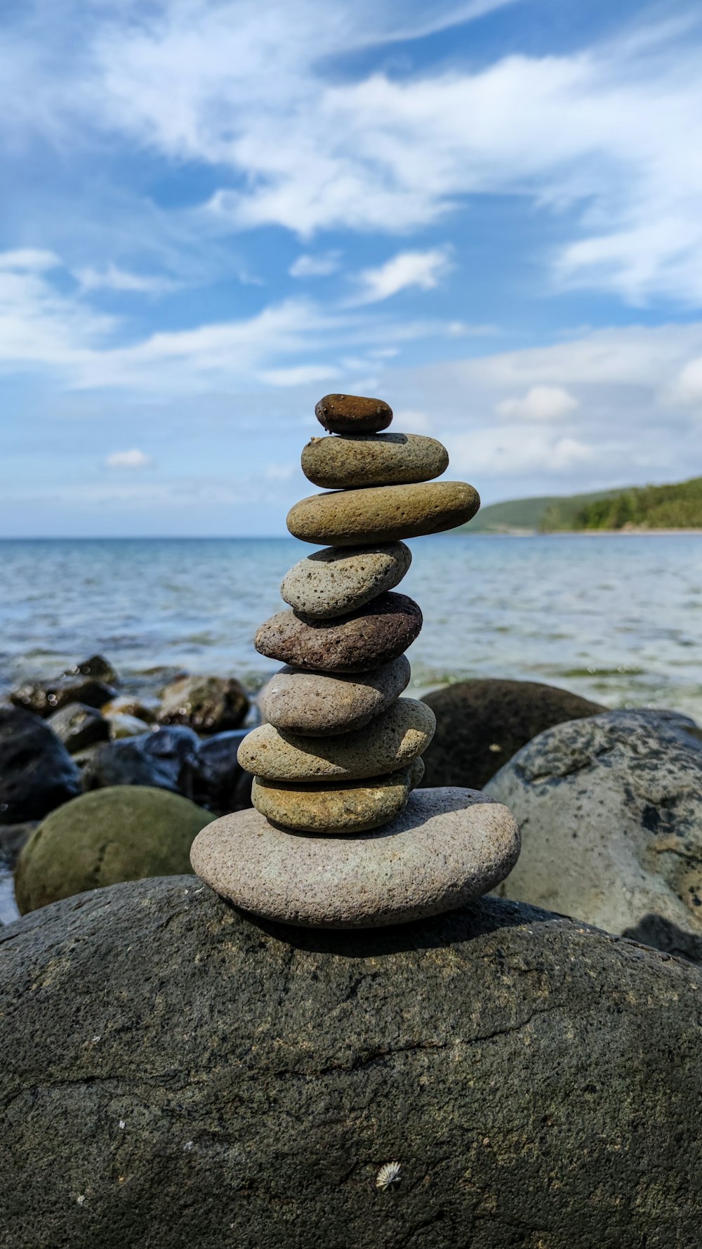 a stack of rocks sitting on top of a rock near the ocean