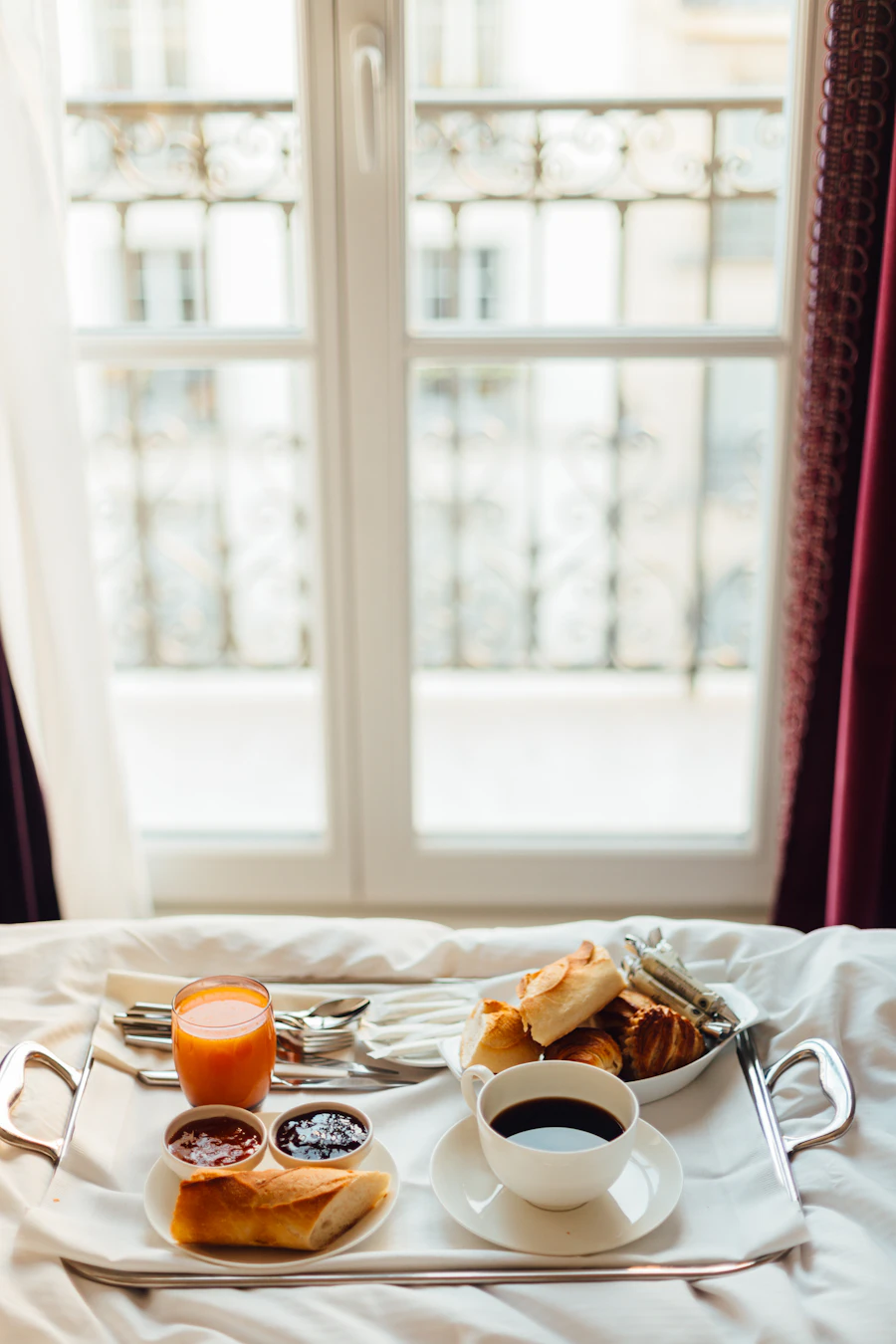 Breakfast tray in bed by an open window