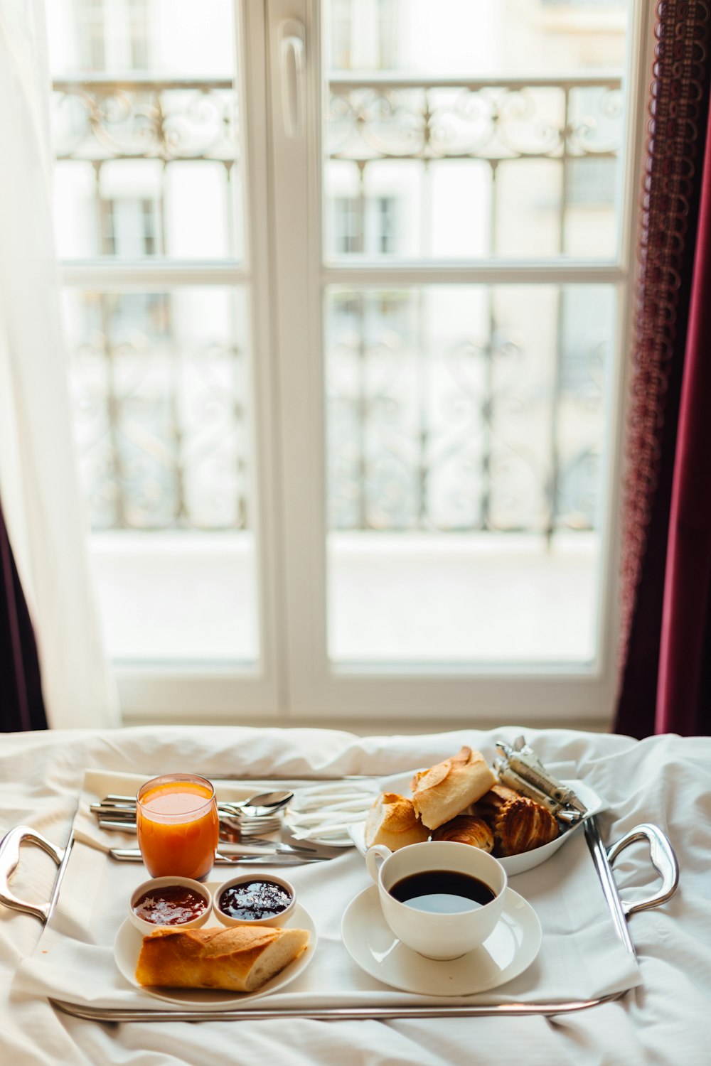 a tray of food on a bed with a cup of coffee