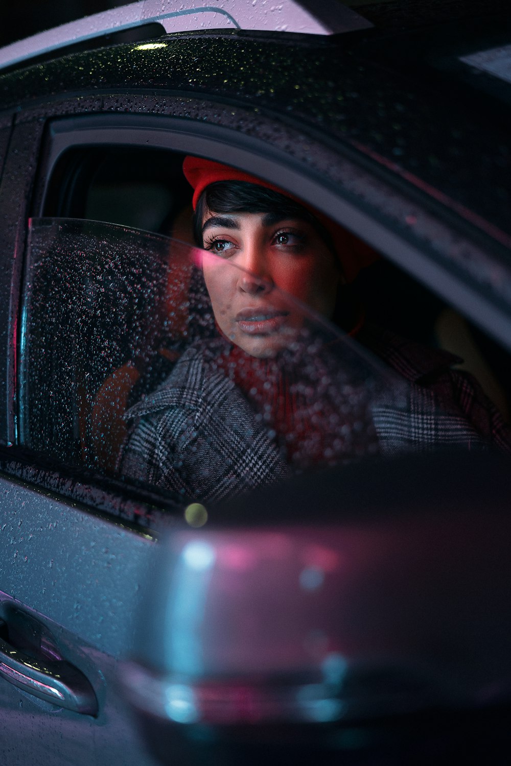 a woman sitting in a car looking out the window