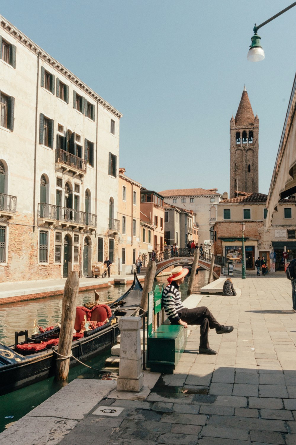 a man sitting on a bench next to a body of water