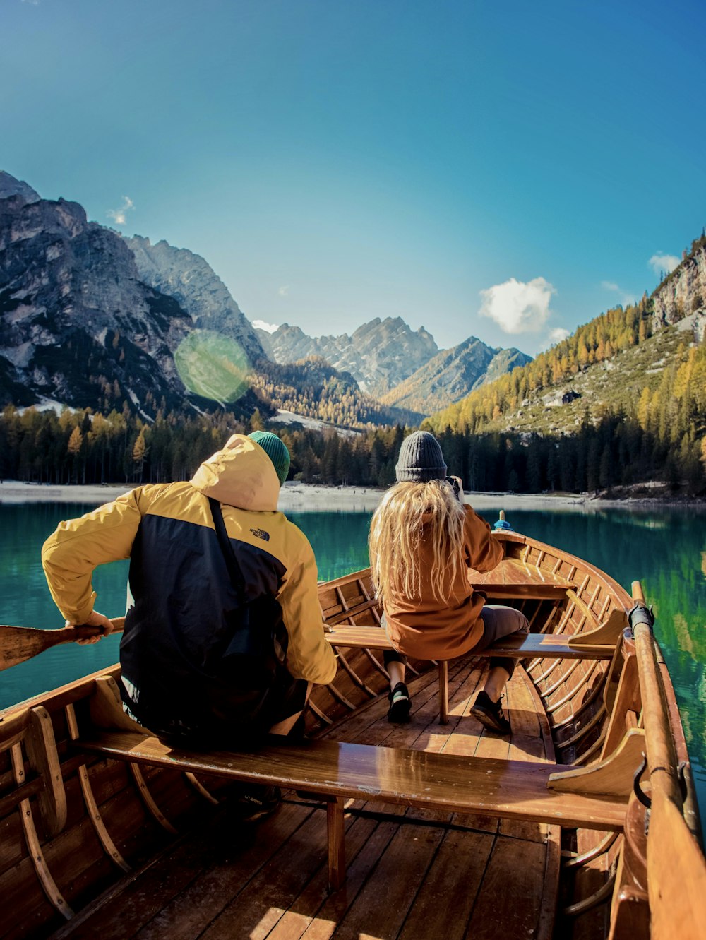 two people sitting in a boat on a lake