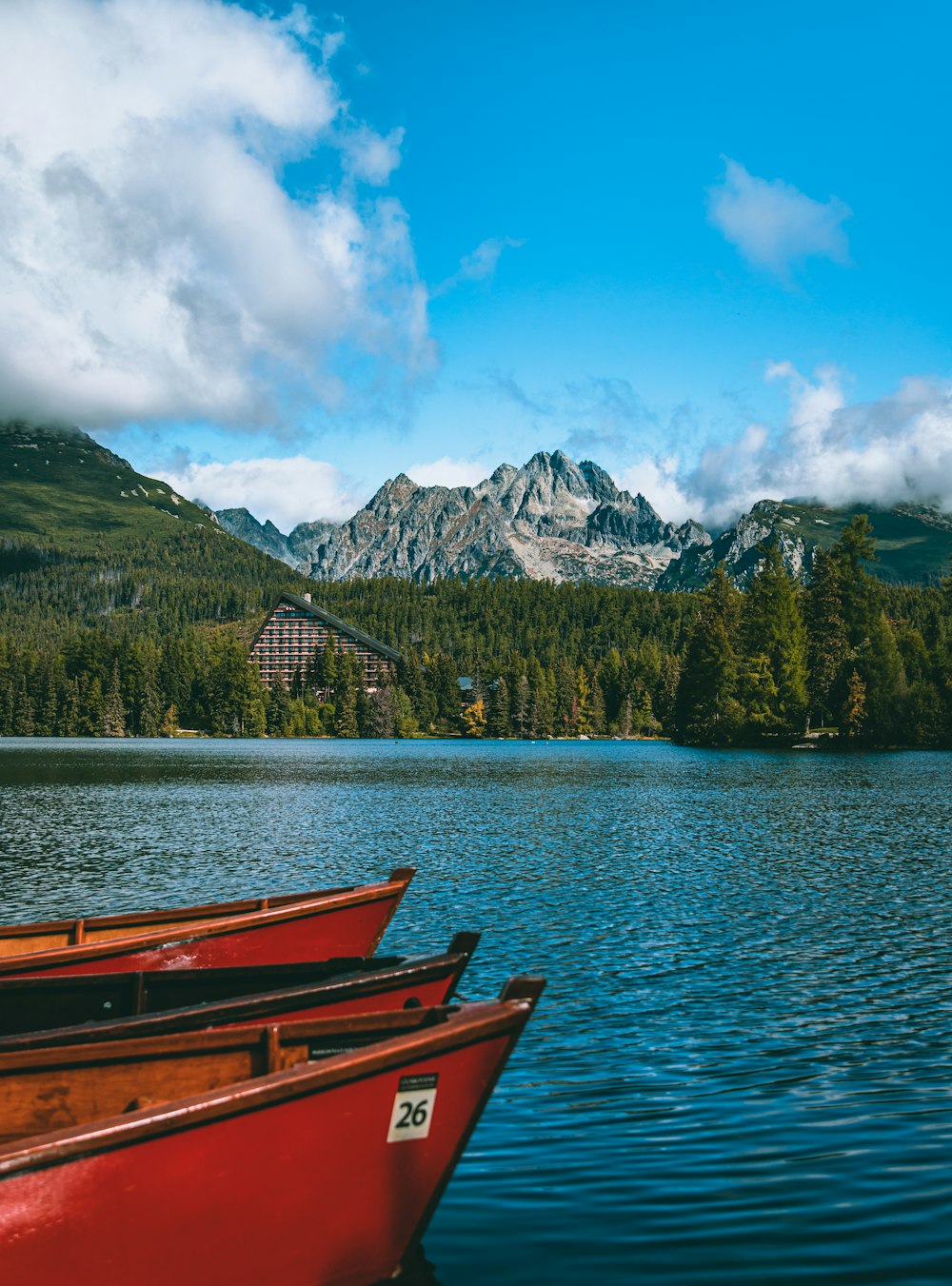 three canoes sitting on a lake with mountains in the background