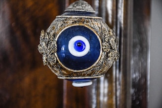 a blue and gold object with an evil eye on it