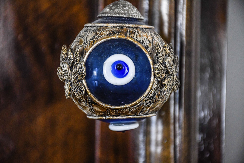 a blue and gold object with an evil eye on it