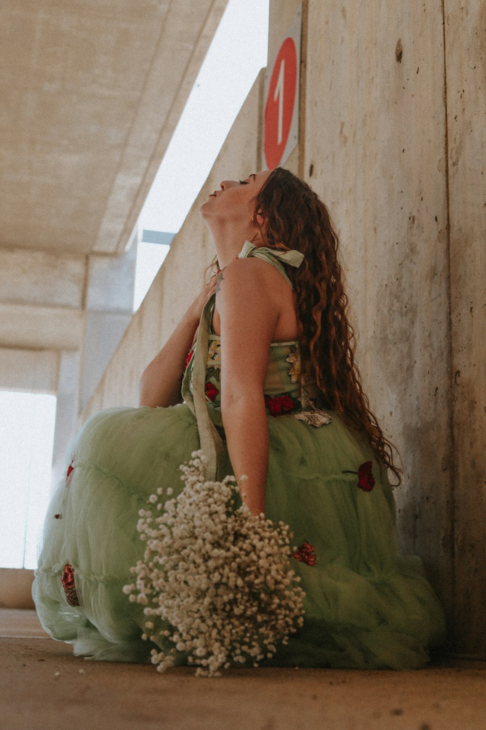 a woman in a green dress sitting on the ground