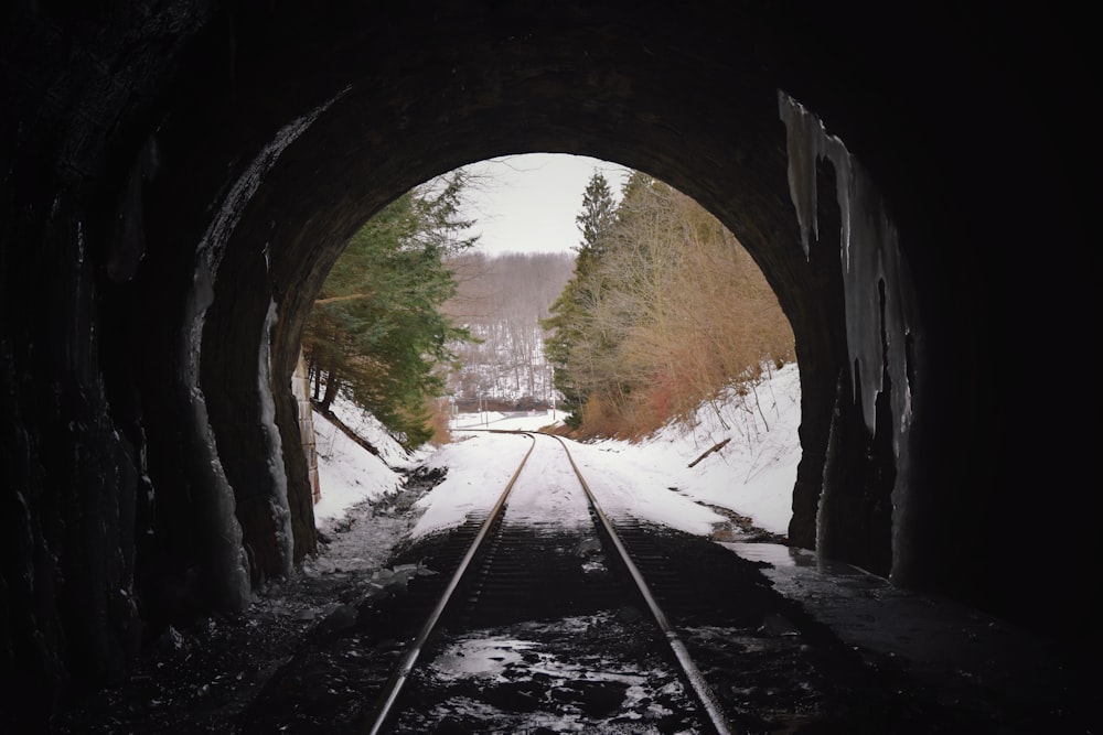 a train track going through a tunnel in the snow