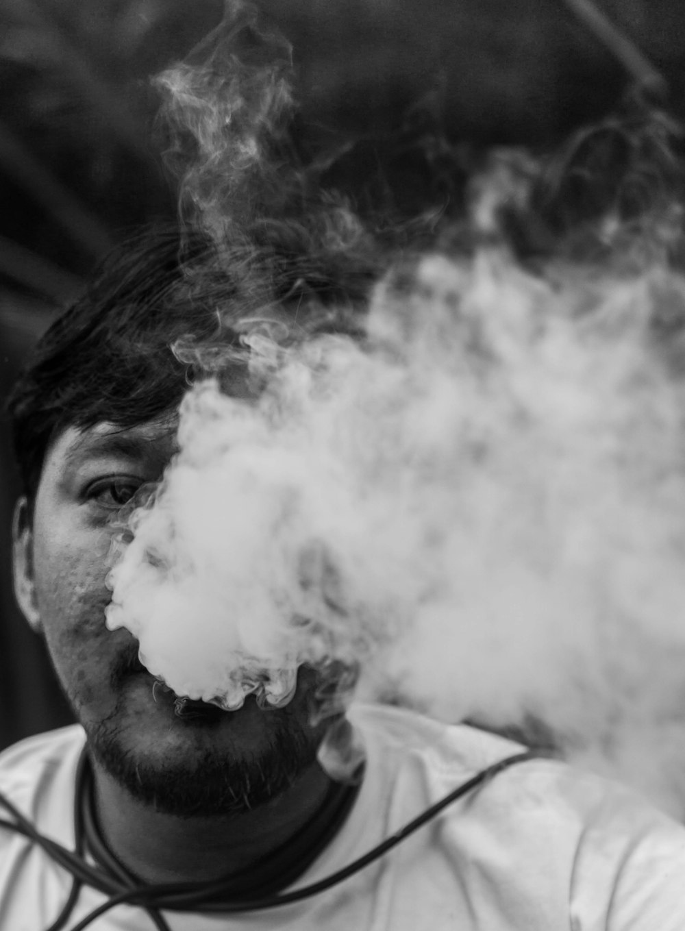 a man smoking a cigarette in a black and white photo