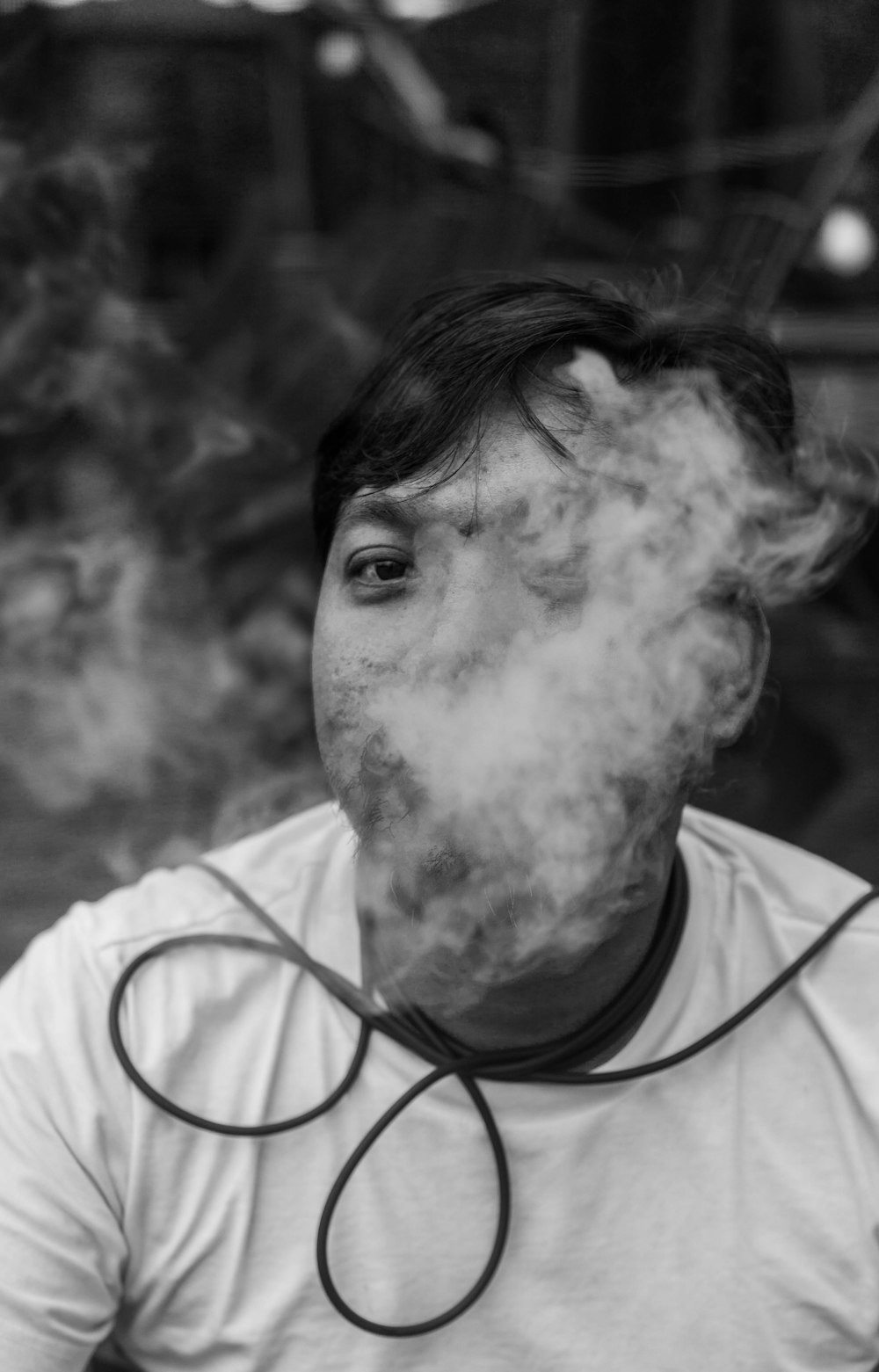 a man is smoking a cigarette in a black and white photo