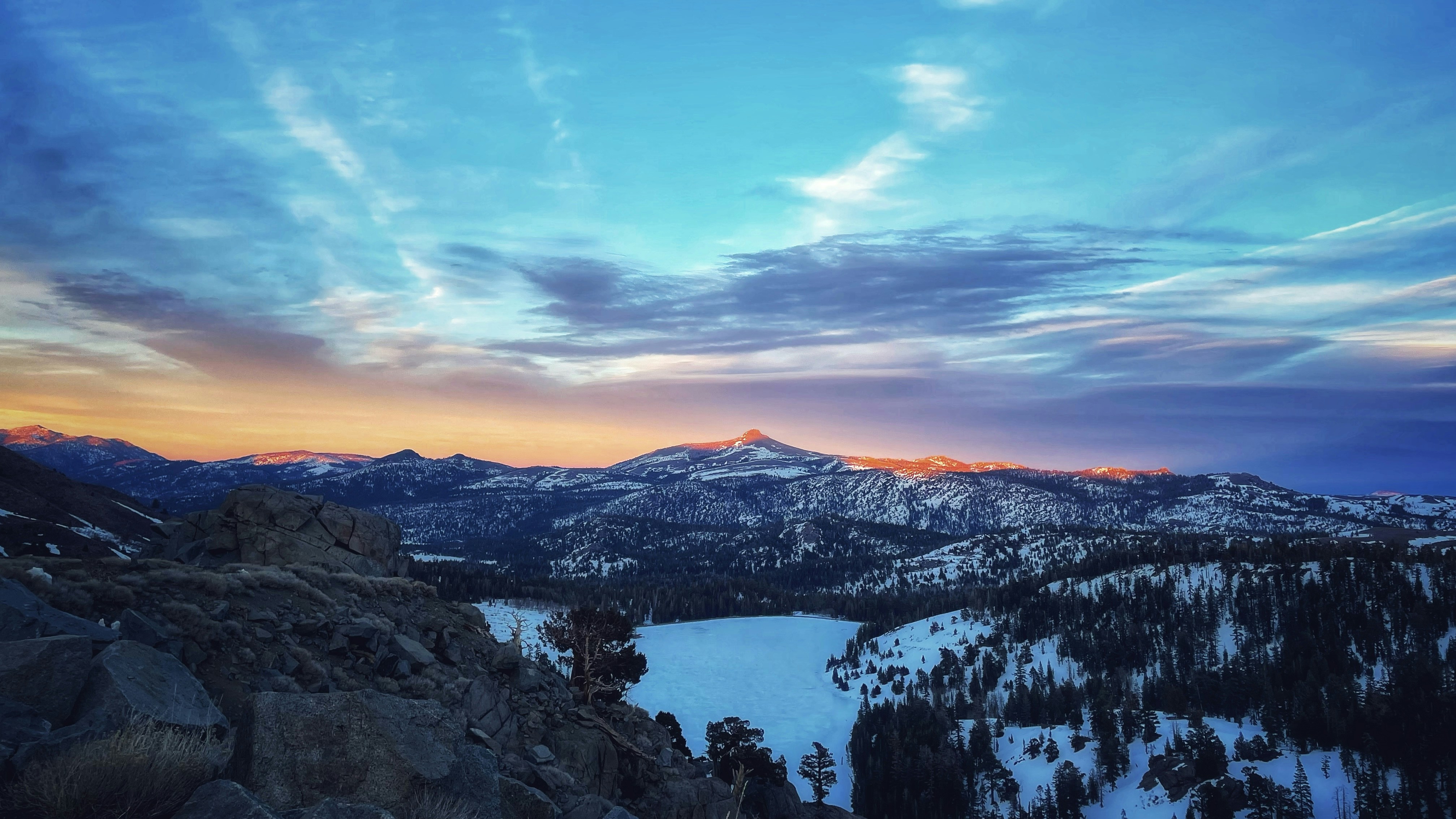 the sun is setting over a mountain range