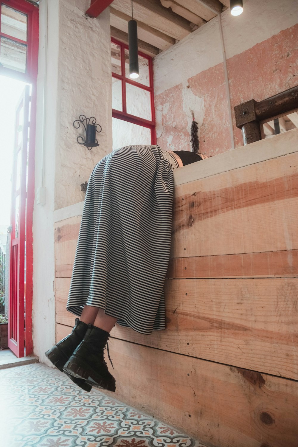 a woman standing on a wooden bench in a room