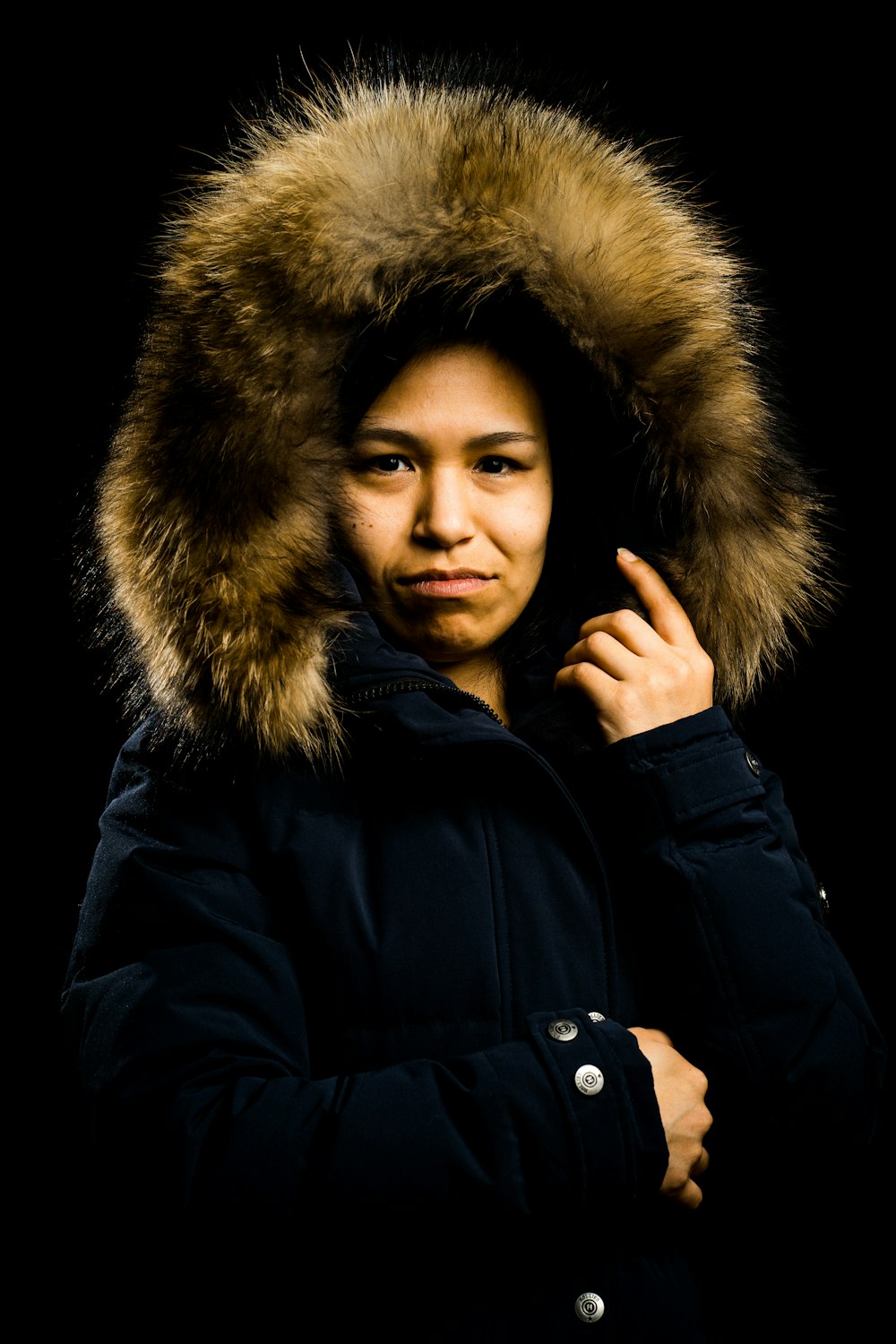 a woman in a black coat with a fur hood