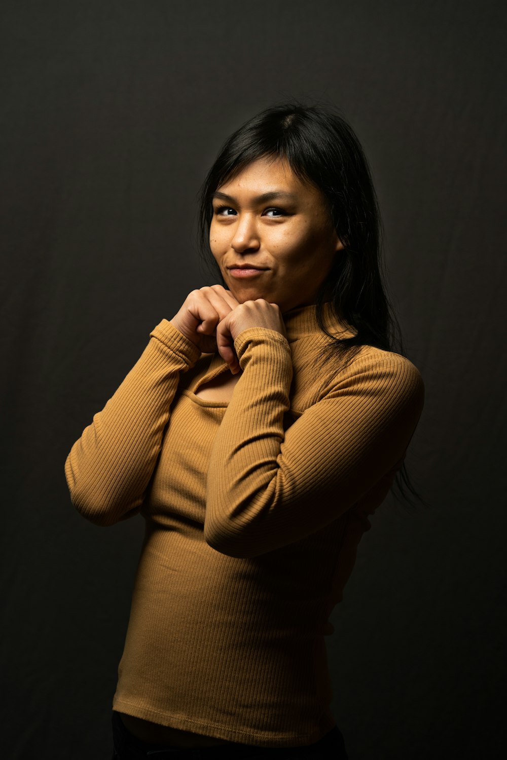 a woman posing for a picture with her hand on her chin