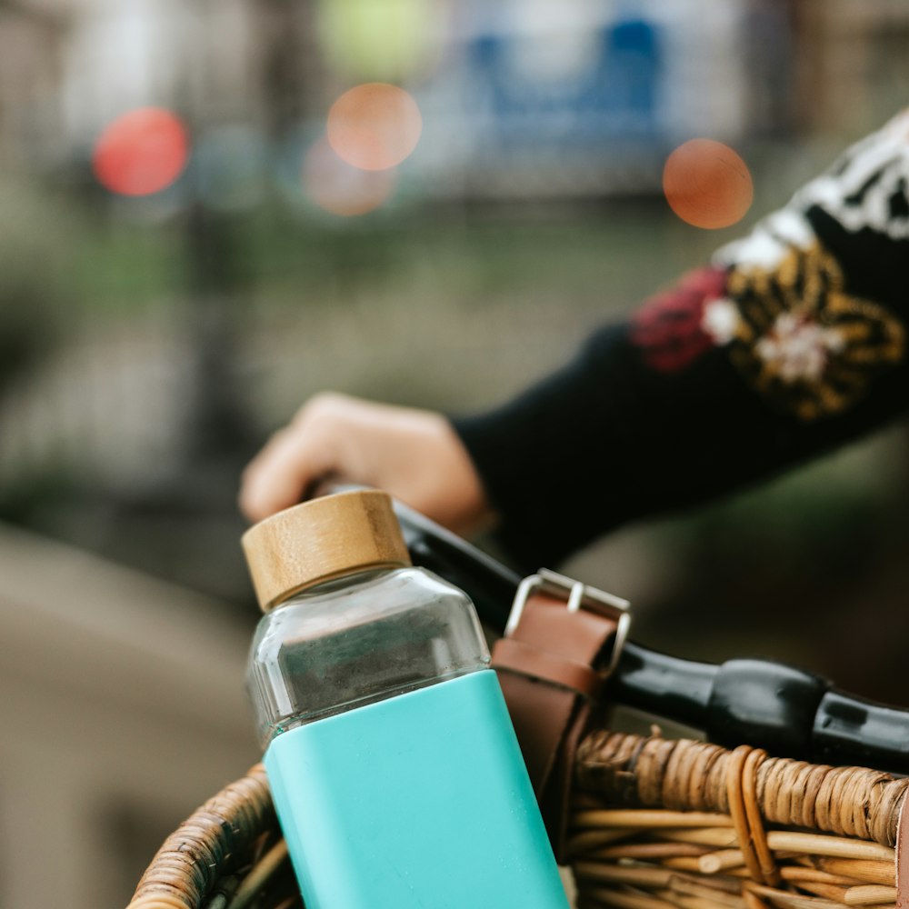 a person riding a bike with a bottle in the basket