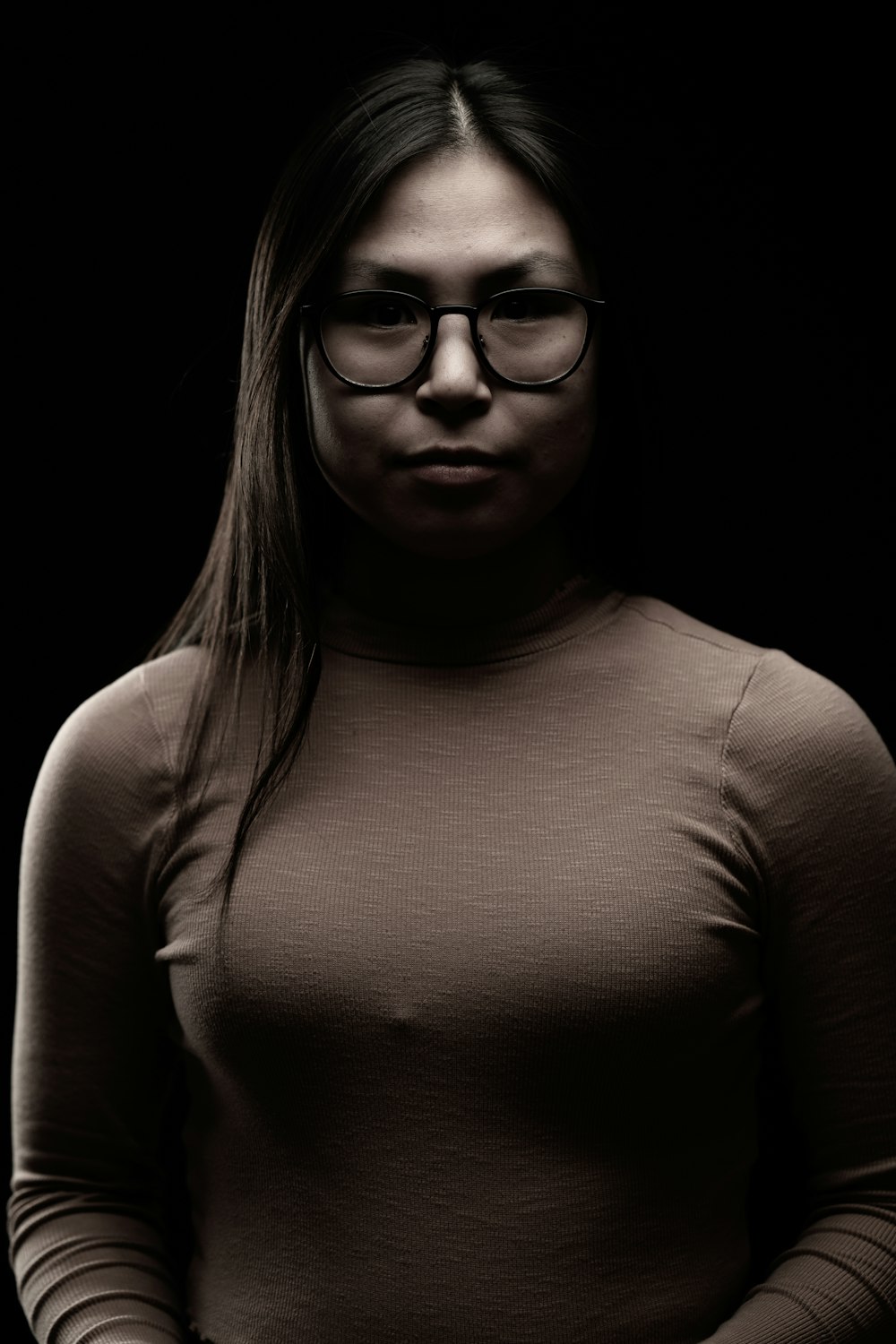 a woman wearing glasses and a turtle neck sweater