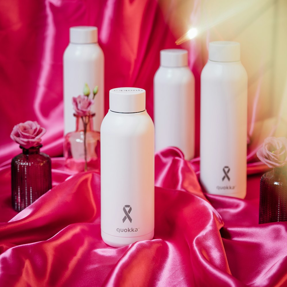 a group of bottles sitting on top of a pink cloth
