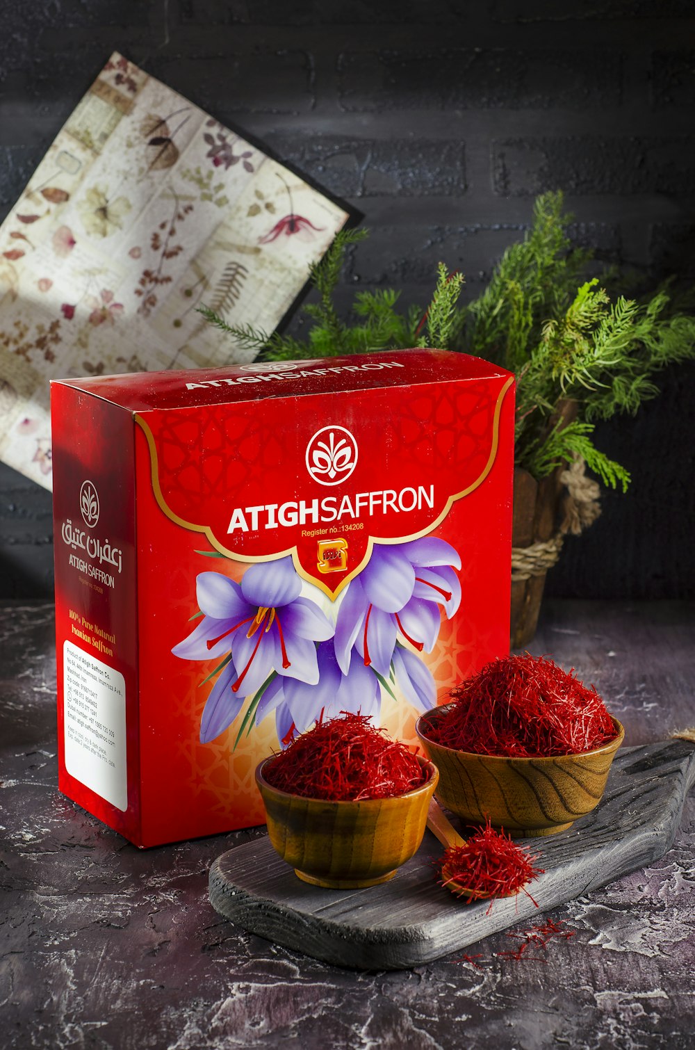 a box of saffron powder next to a bowl of saffron