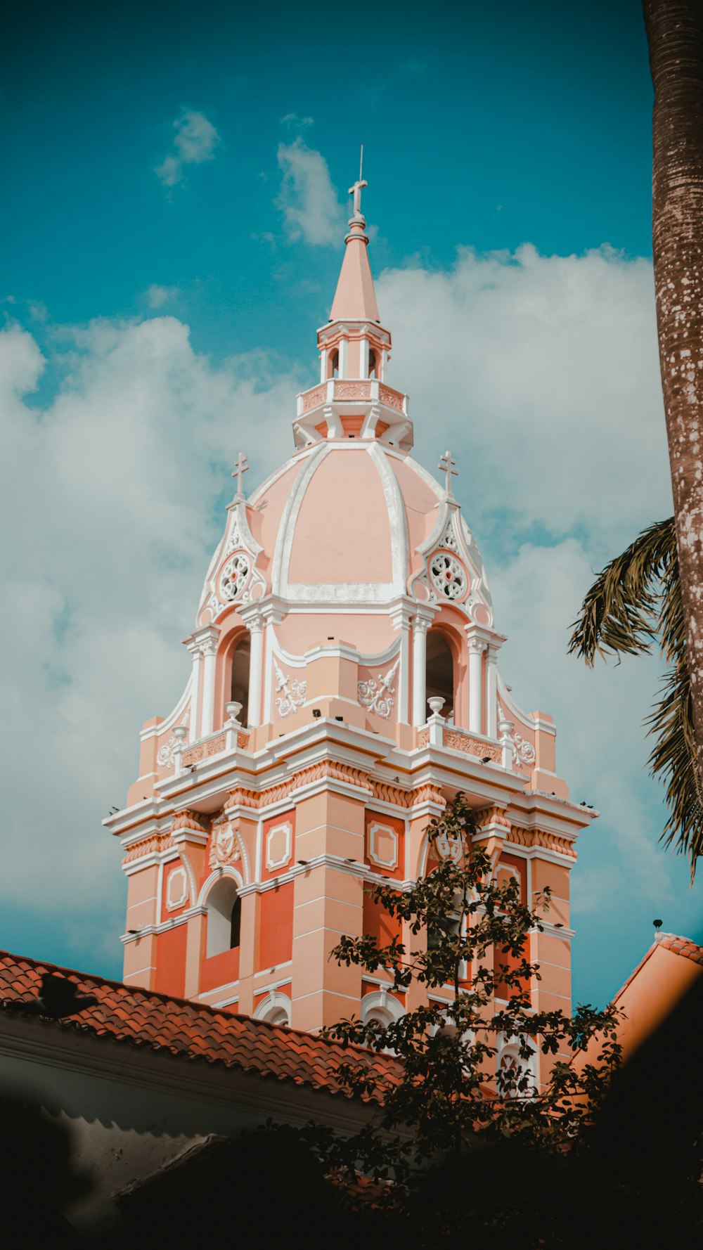 a pink and white building with a palm tree in front of it