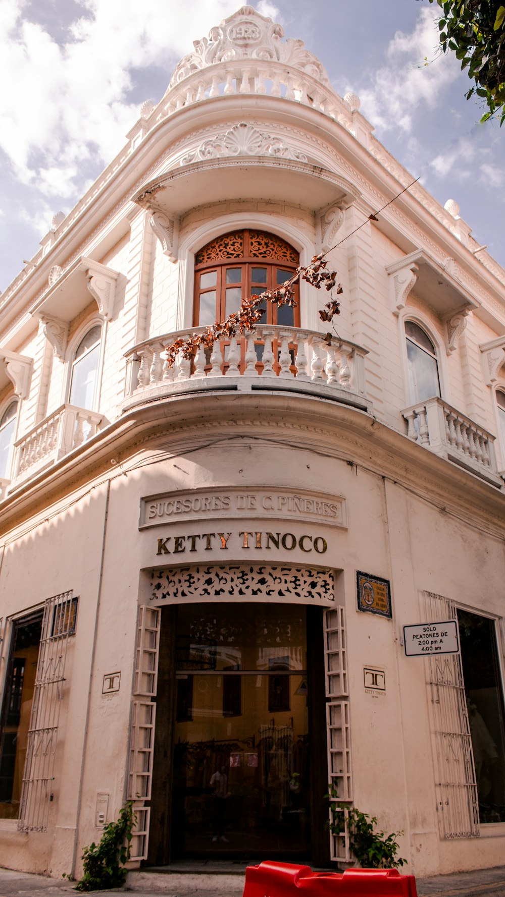 Un edificio blanco con un banco rojo frente a él