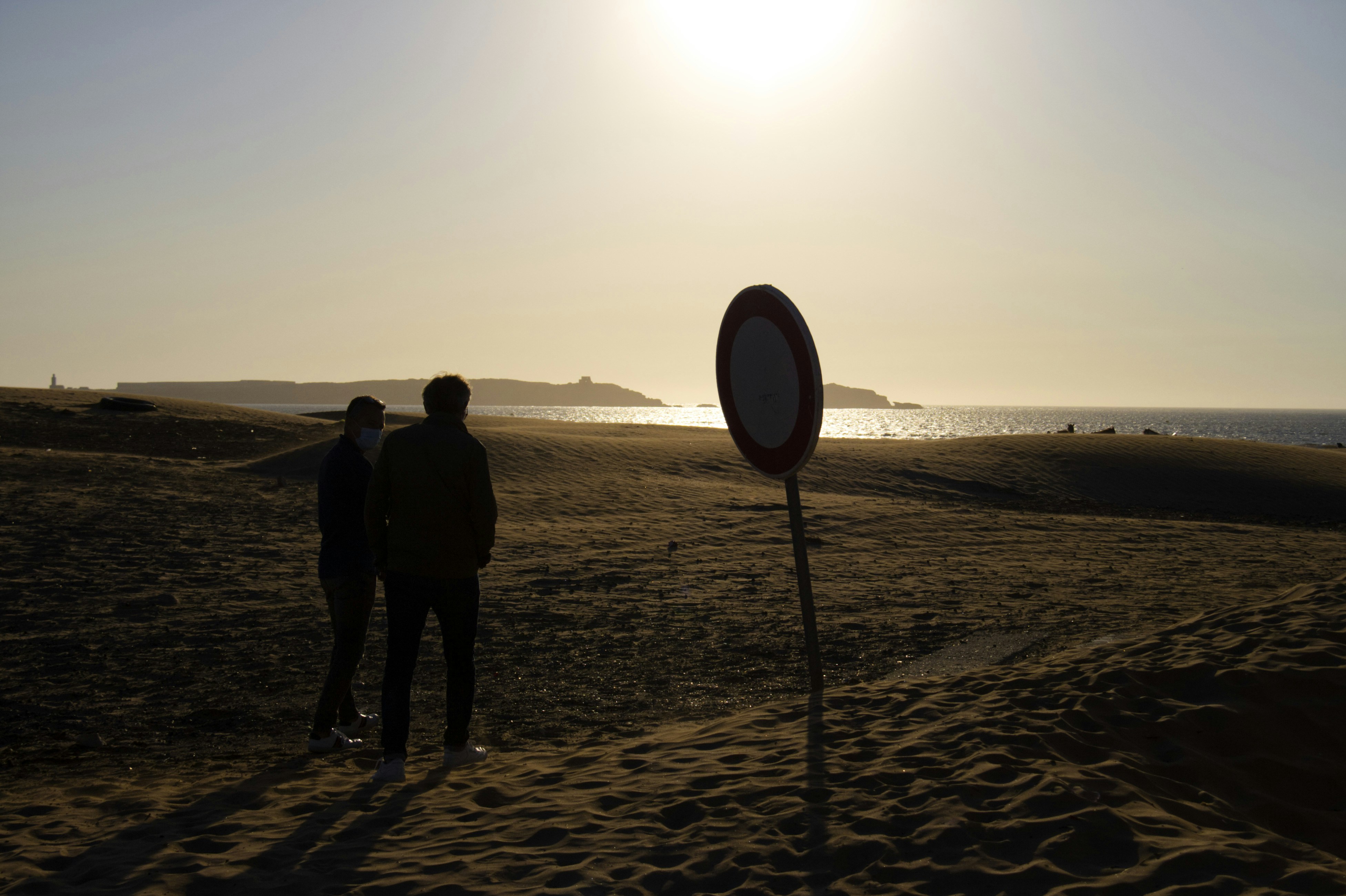 Un couple de personnes debout au sommet d’une plage de sable