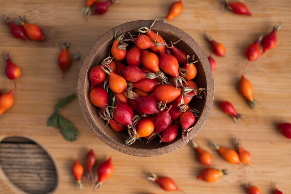 a wooden bowl filled with lots of red berries