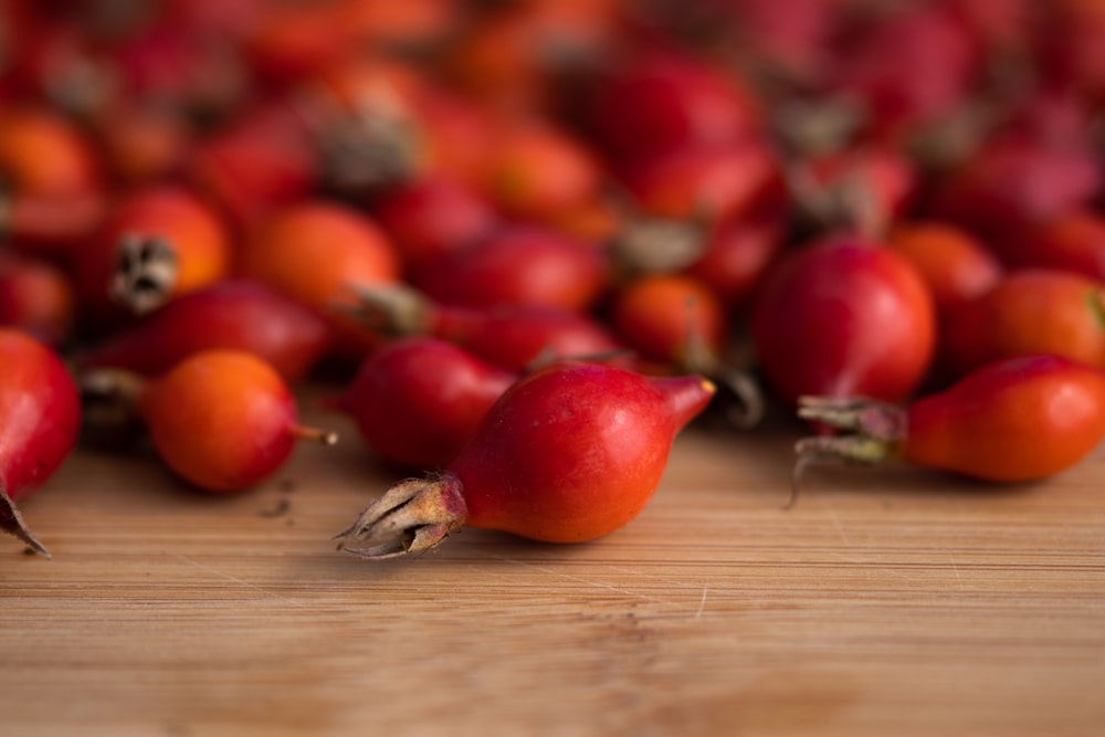 a wooden table topped with lots of red fruit