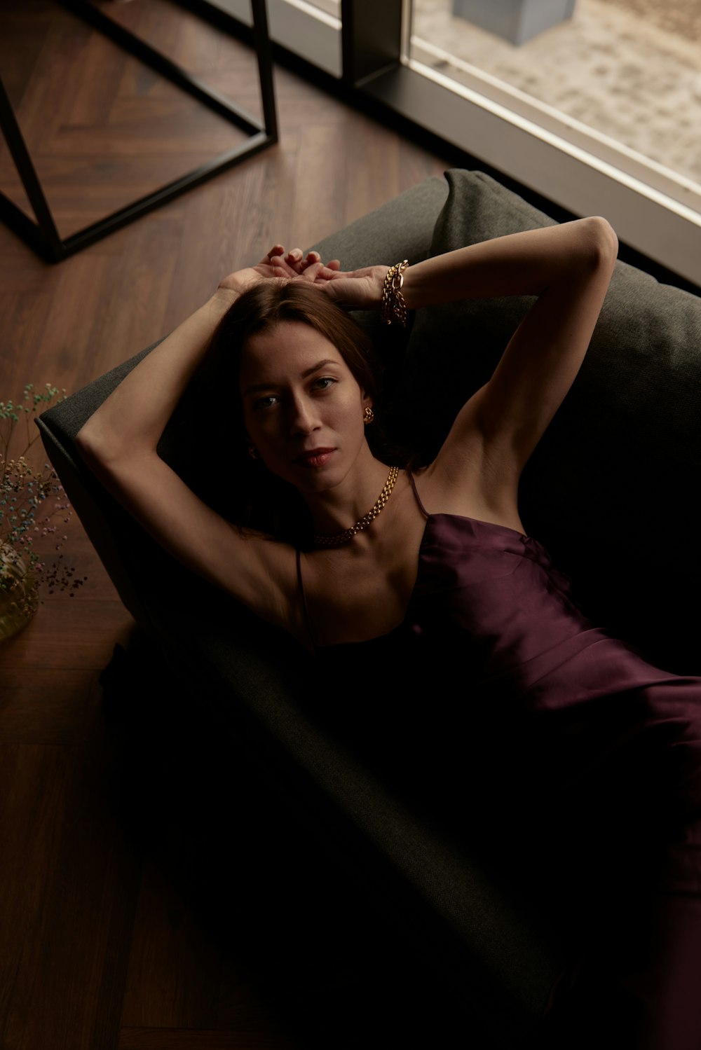 uma mulher em um vestido roxo deitado em um sofá