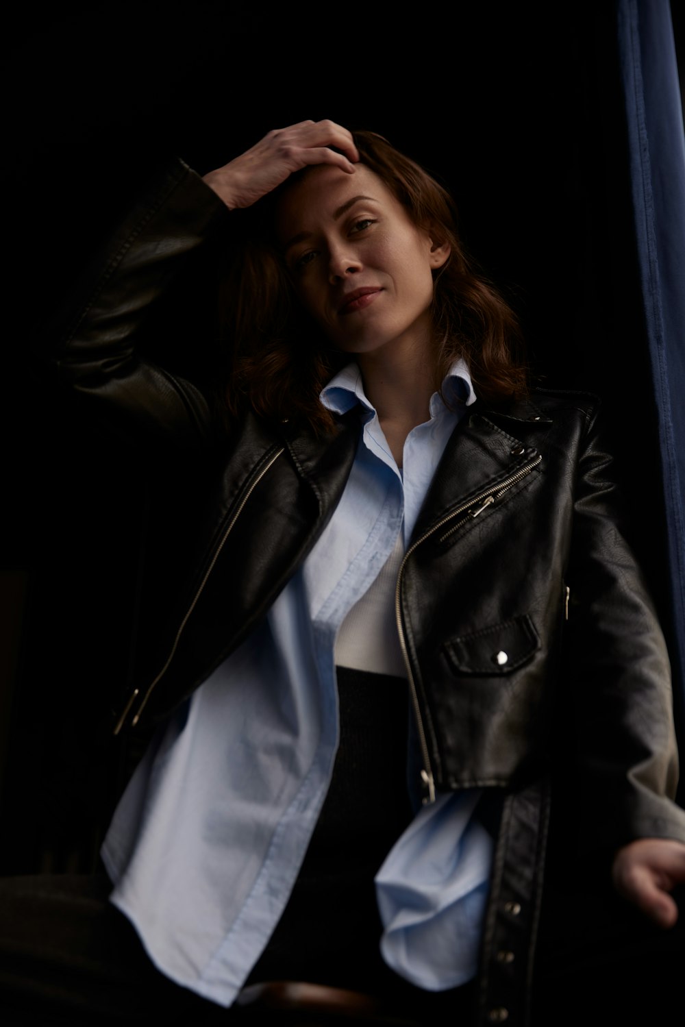a woman wearing a black leather jacket and a white shirt