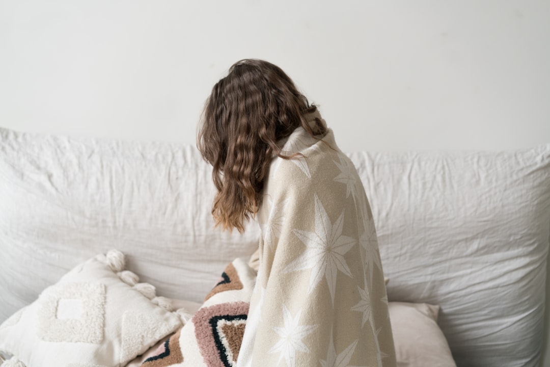 a woman sitting on a couch with a blanket,