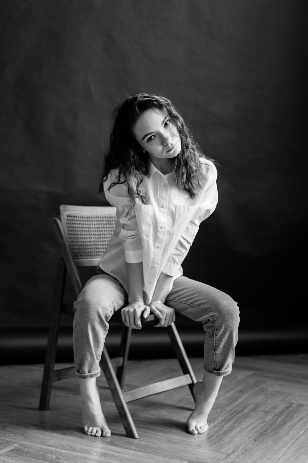 a black and white photo of a woman sitting on a chair